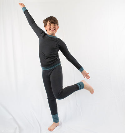 Smiling child modeling black TK Clothing Inc base layer set, handmade in North Saanich, BC