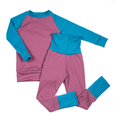 Purple and teal handmade kids’ base layer set from TK Clothing Inc on white background